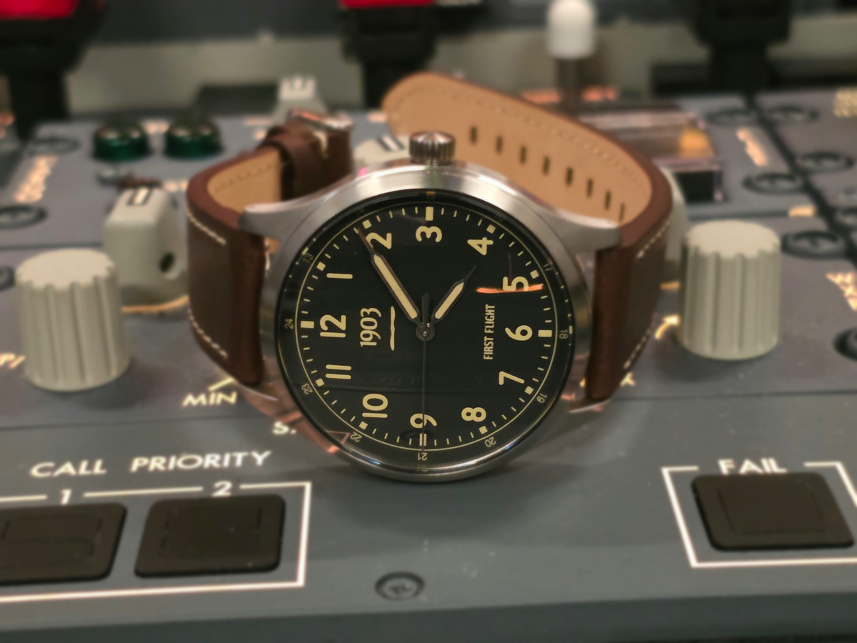 First Flight 40 prototype watch resting on a Boeing aircraft center pedestal panel