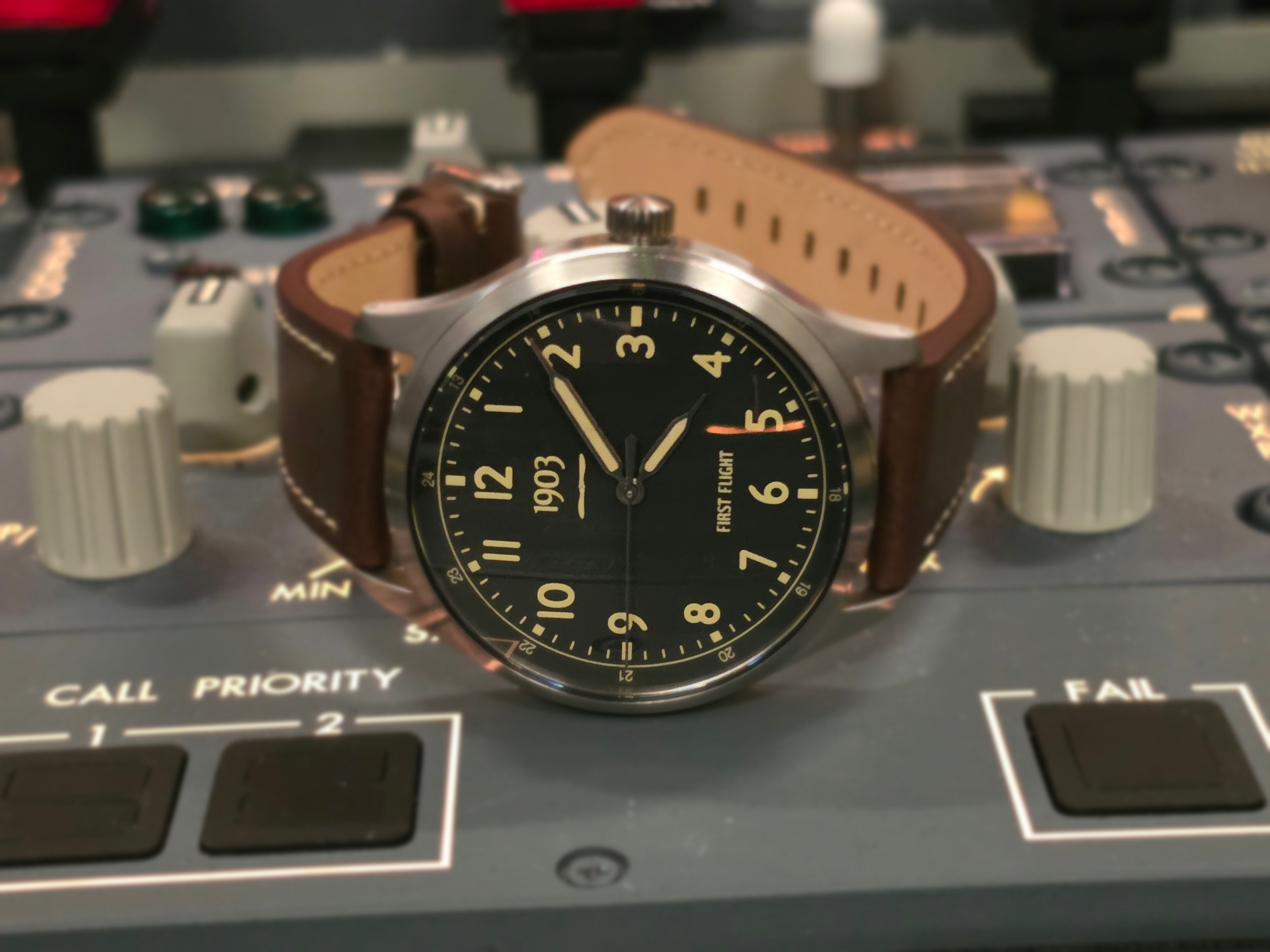 First Flight 40 prototype watch resting on a Boeing aircraft center pedestal panel